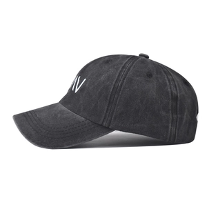 Close-up of white letter embroidery on a washed vintage charcoal cotton baseball cap