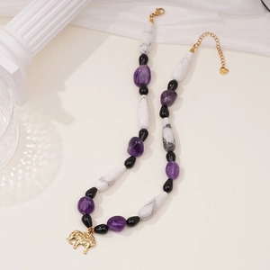 Detail of amethyst and marble beads necklace featuring a golden elephant charm