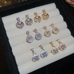 Detailed display of square and heart zircon earrings in gold and silver finishes