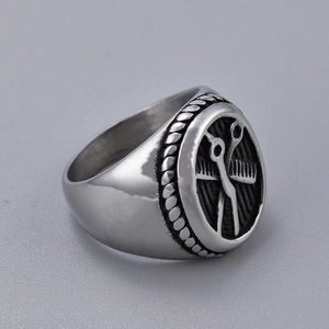 Macro shot of silver barber ring featuring embossed scissors and comb on vintage steel