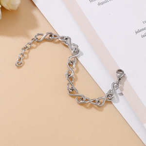 Bracelet infini minimaliste en acier inoxydable argenté avec fermoir mousqueton sur fond beige