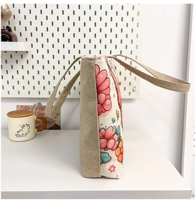 Detailed side view of ethnic floral canvas tote bag with textured light brown burlap handles