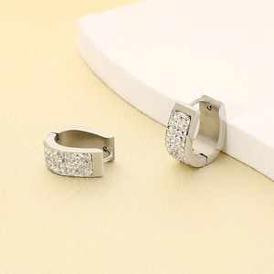 Detailed view of silver U-shaped earrings with four rows of inlaid zircon stones