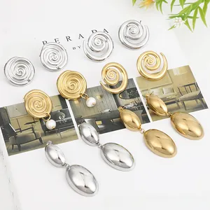 Macro shot of liquid metal heart stud earrings in gold and silver finish on a magazine