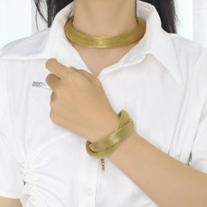 Detailed view of women's mesh woven gold choker necklace and wrap bracelet set on model