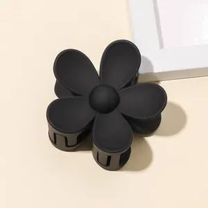 Close-up of matte black five-petal flower hair claw clip with professional grip teeth