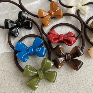 Detail of colorful acrylic bow hair ties in black, brown, blue, red, and green colors