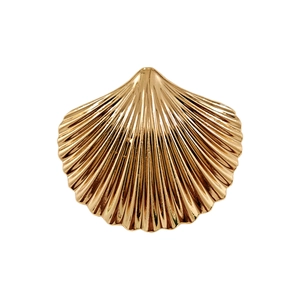 Detail of a golden seashell hair accessory with radiant textures and a metallic finish