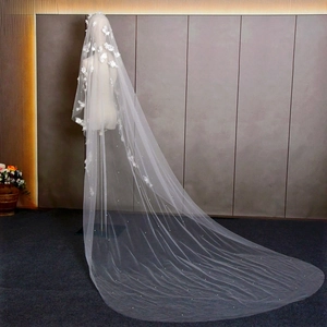 Detail of white bridal veil featuring 3D floral lace and pearls on cathedral length tulle