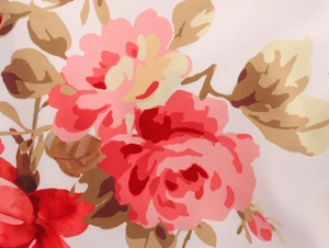 Detail close-up of French floral print fabric featuring red and pink flowers on beige