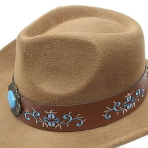 Detail of brown cowboy hat with leather band, floral embroidery and turquoise gemstone