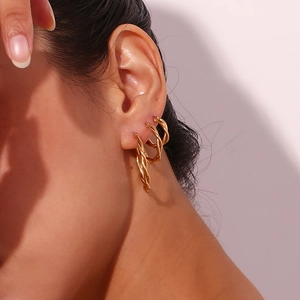 Close-up of twisted rope texture hoop earrings in 18K gold finish for a minimalist style