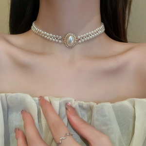 Gros plan détaillé du collier double couche avec perle baroque ovale et strass brillants