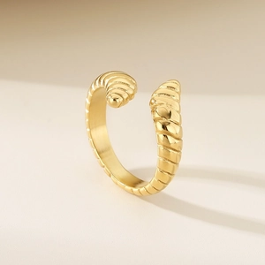 Vue détaillée de la texture spirale dorée et finition polie sur une bague ajustable en acier