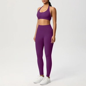Dettaglio del set yoga a coste viola scuro con reggiseno all'americana e leggings a vita alta