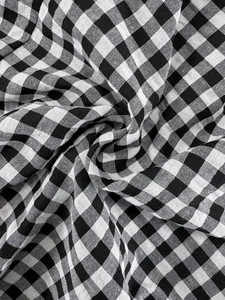 Detailed close-up showing the black and white checkered linen fabric texture of maternity overalls