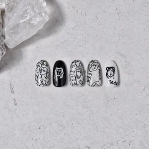 Nahaufnahme minimalistischer Nagelaufkleber in Schwarz-Weiß mit abstrakten Gesichtslinien