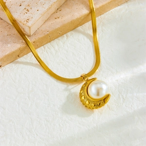Golden crescent moon pendant necklace with white pearl on beige marble background