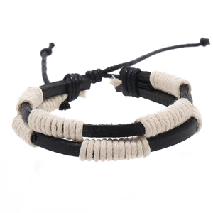 Detail of handmade black leather bracelet featuring cream cotton cord weave and knot