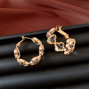 Détail de boucles d'oreilles trèfle plaquées or 18 carats avec cristaux sur velours