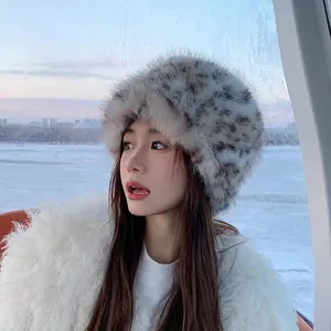 Winter faux fur leopard print bucket hat with ear protection in snow background