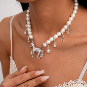Close-up of pearl necklace featuring a silver horse pendant and small star charms