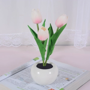 Close-up of artificial pink tulip LED night light in a white ceramic pot decoration