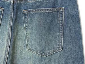 Detail of blue denim back pocket with yellow stitching and vintage washed texture