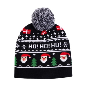 Close-up of black knitted Christmas hat with Ho Ho Ho text and Santa Claus patterns