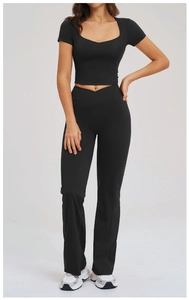 Detail of black yoga set featuring a cross-waist flare pant and short sleeve crop top