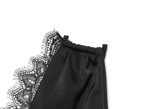 Detailed close-up of delicate eyelash lace trim on a black silk neckline and shoulder