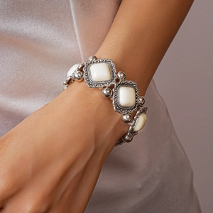 Detail of vintage silver metal geometric bracelet with white shell inlay on model