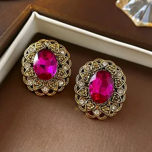 Vintage style oval magenta gemstone earrings with antique gold floral pattern engraving