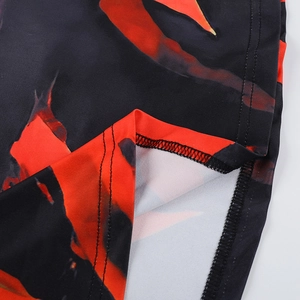 Détail de l'ourlet à double couture et imprimé flamme rouge sur tissu extensible noir