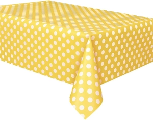 Close-up of a rectangular yellow tablecloth with white polka dots for birthday parties