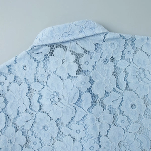 Detail of light blue lace shirt featuring intricate floral crochet on collar and shoulder