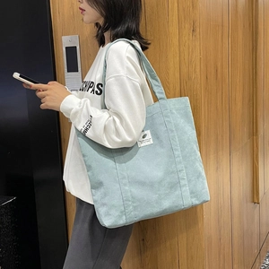 Minimalist mint green corduroy tote bag for women featuring a stylish logo patch