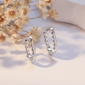 Sleek silver wave textured hoop earrings for women with minimalist jewelry aesthetics