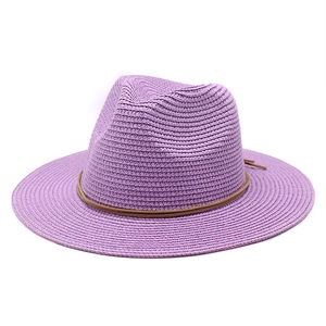 Macro shot of light purple straw fedora hat with fine woven texture and brown cord