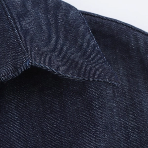 Dettaglio del vestito denim blu scuro con doppia cucitura e trama in twill di cotone
