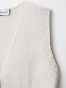 Close-up of the beige knitted tank top showing detailed shoulder stitching and ribbed texture