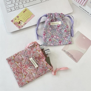 Pochettes de rangement à fleurs pour soins de la peau présentées sur un bureau blanc