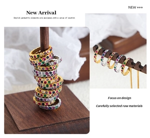 Macro detail of rainbow zircon rings in gold and silver plating on wooden stands