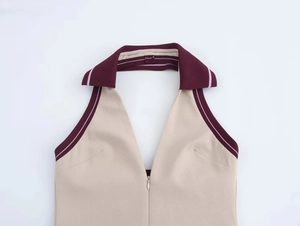 Detail of beige halter neckline with burgundy ribbed trim and a hidden front zipper