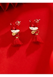 Detail of Chinese style red tassel earrings with enamel zodiac and gold coin accents