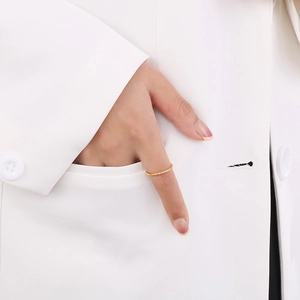 Close-up of minimalist gold ring with row of micro-inlaid diamonds on model's hand