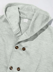Detail of light gray hooded trench coat showing double-breasted buttons and collar texture