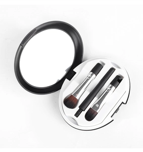 Travel makeup brush set in a round black case with integrated mirror for quick touch-ups