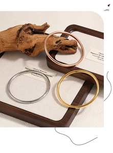 Close-up of set of three 4mm polished metal bangles in gold, silver and rose gold