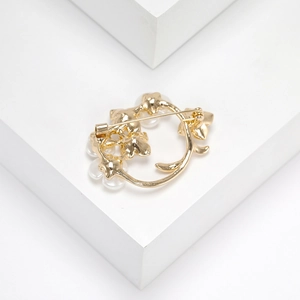 Detailed back view of a golden floral pearl brooch showing the secure pin mechanism